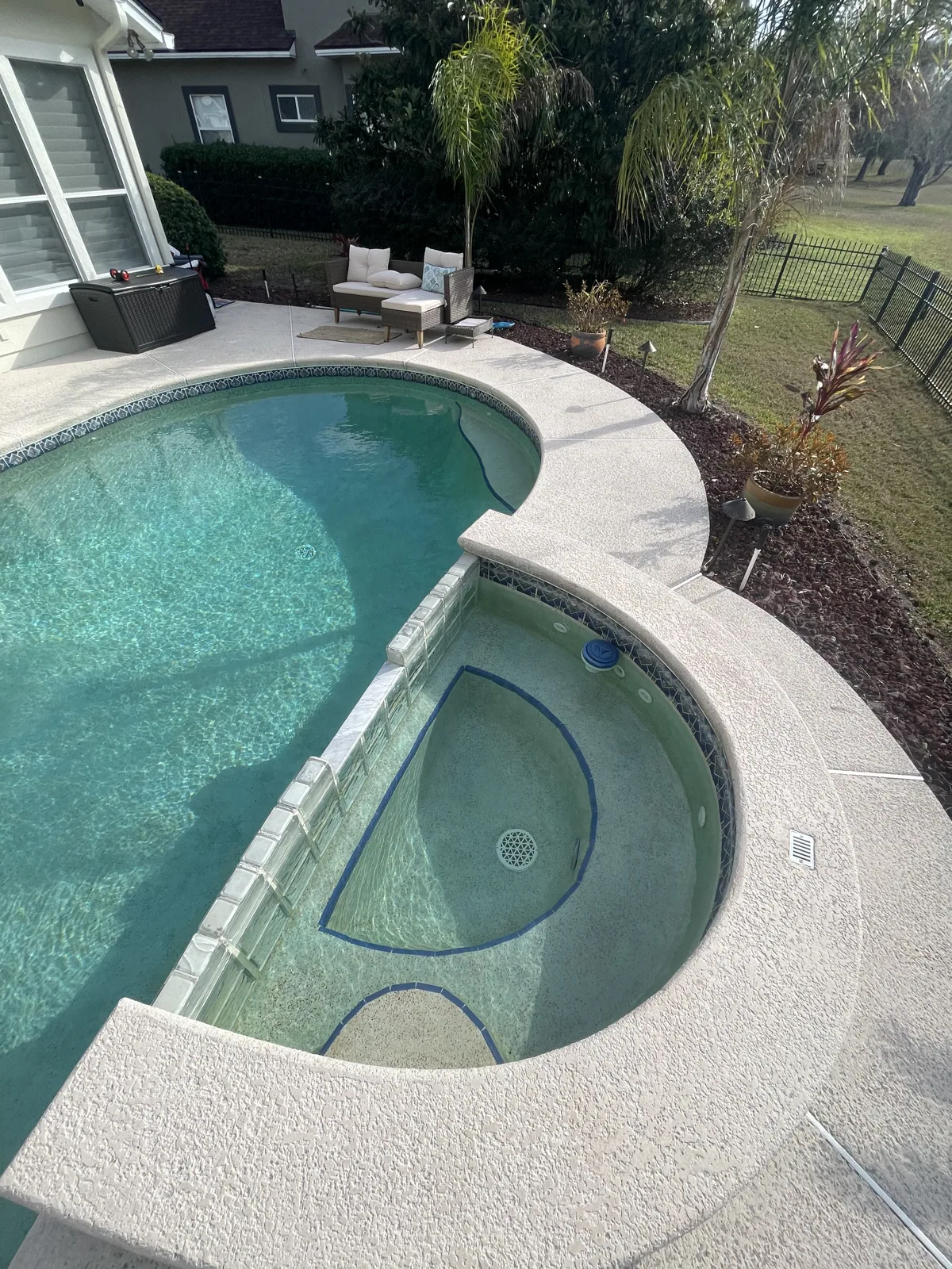 Custom pool and raised spa with glass tile, viewed from the deck