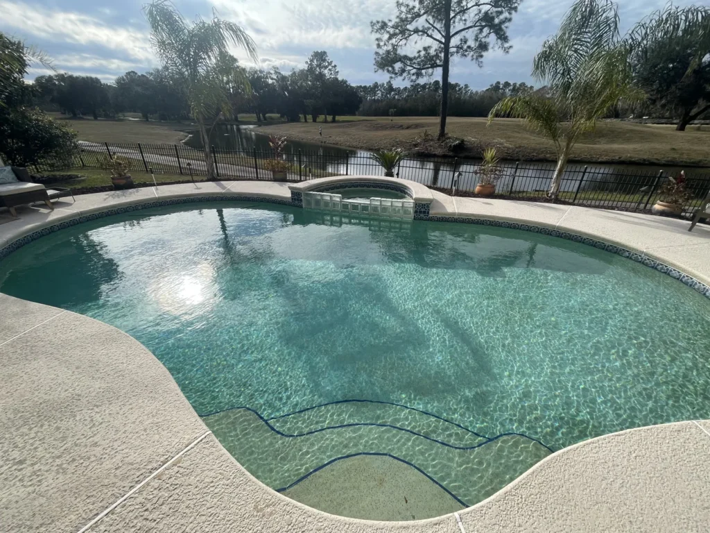 Custom pool and raised spa viewed across the water toward the lake