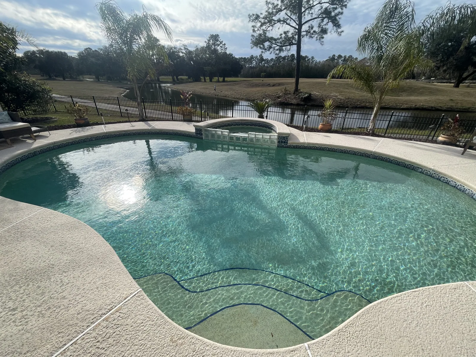 Custom pool and raised spa viewed across the water toward the lake