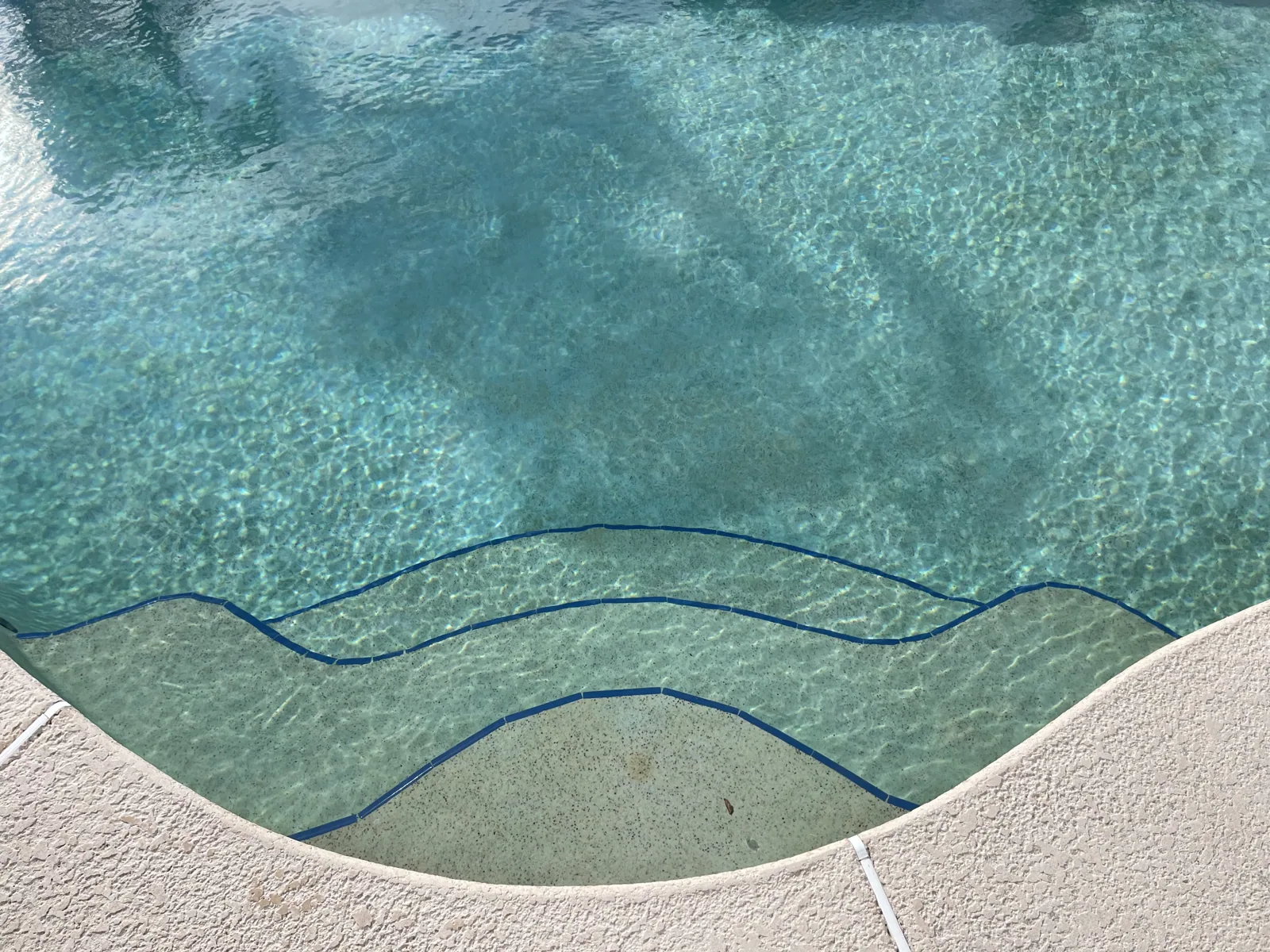 Water feature detail on a custom pool showing the spa spillover and tile