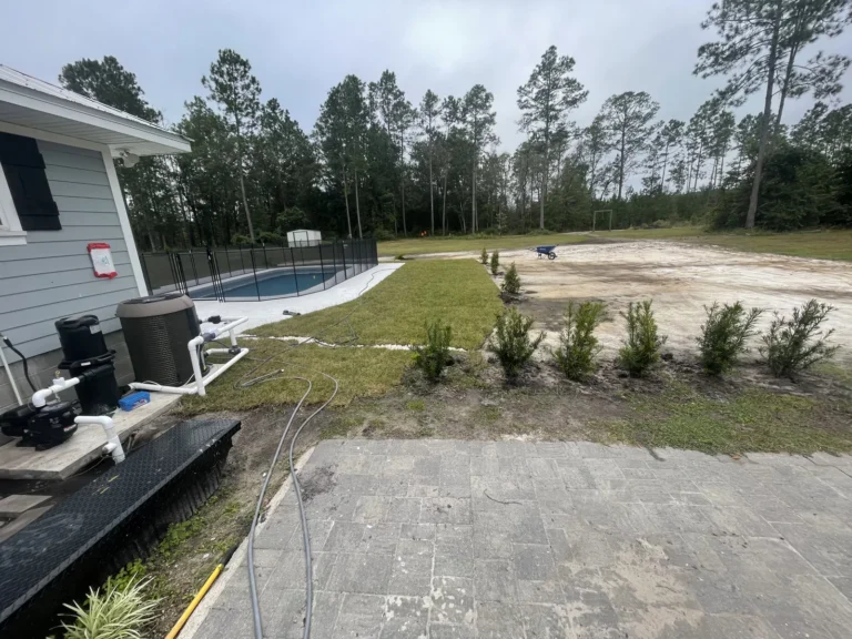 Finished fiberglass pool with a full concrete deck and mesh safety fence in Clay County, Florida