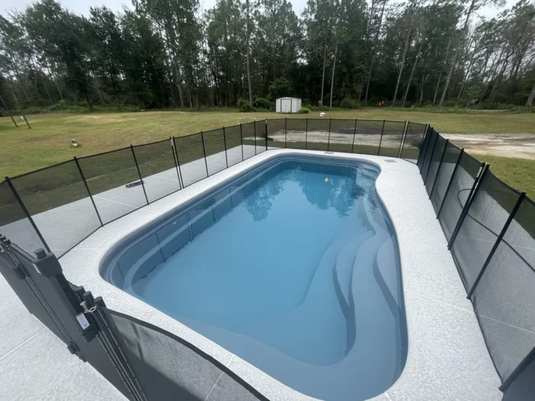 Fiberglass pool and concrete deck behind a newly built Clay County home