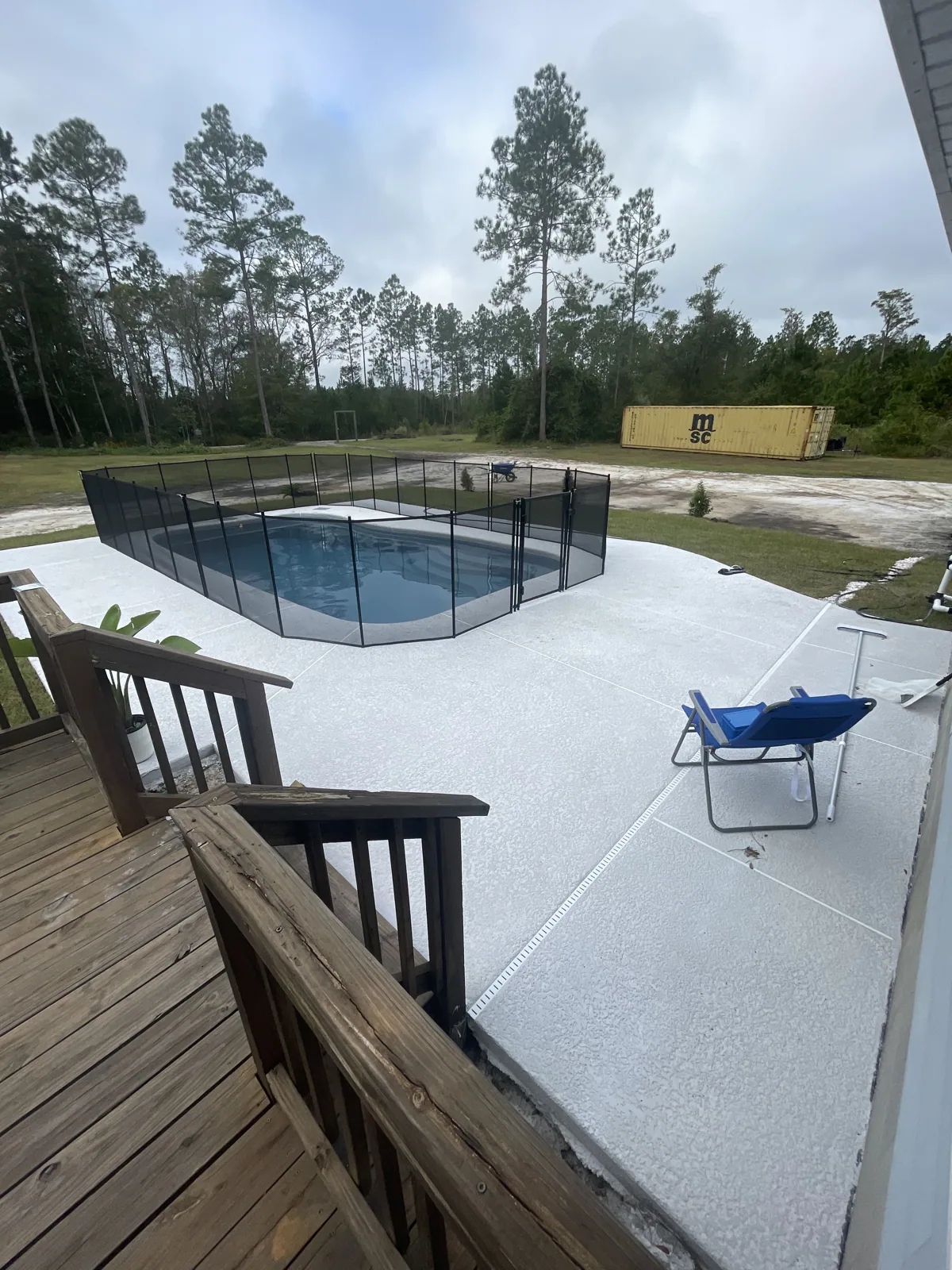 Fiberglass pool viewed from the deck with mesh safety fencing installed