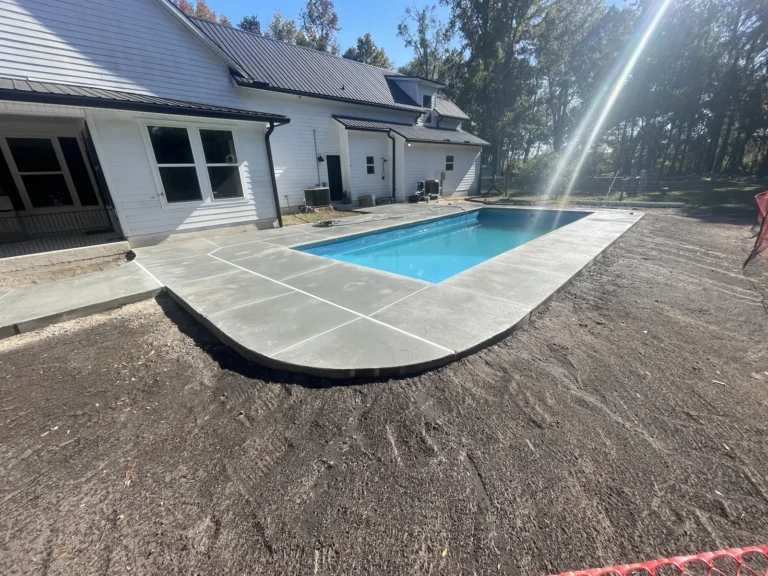 Concrete pool deck finished around a fiberglass pool at a new home