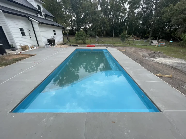 Completed fiberglass pool and concrete deck behind a new Northeast Florida home