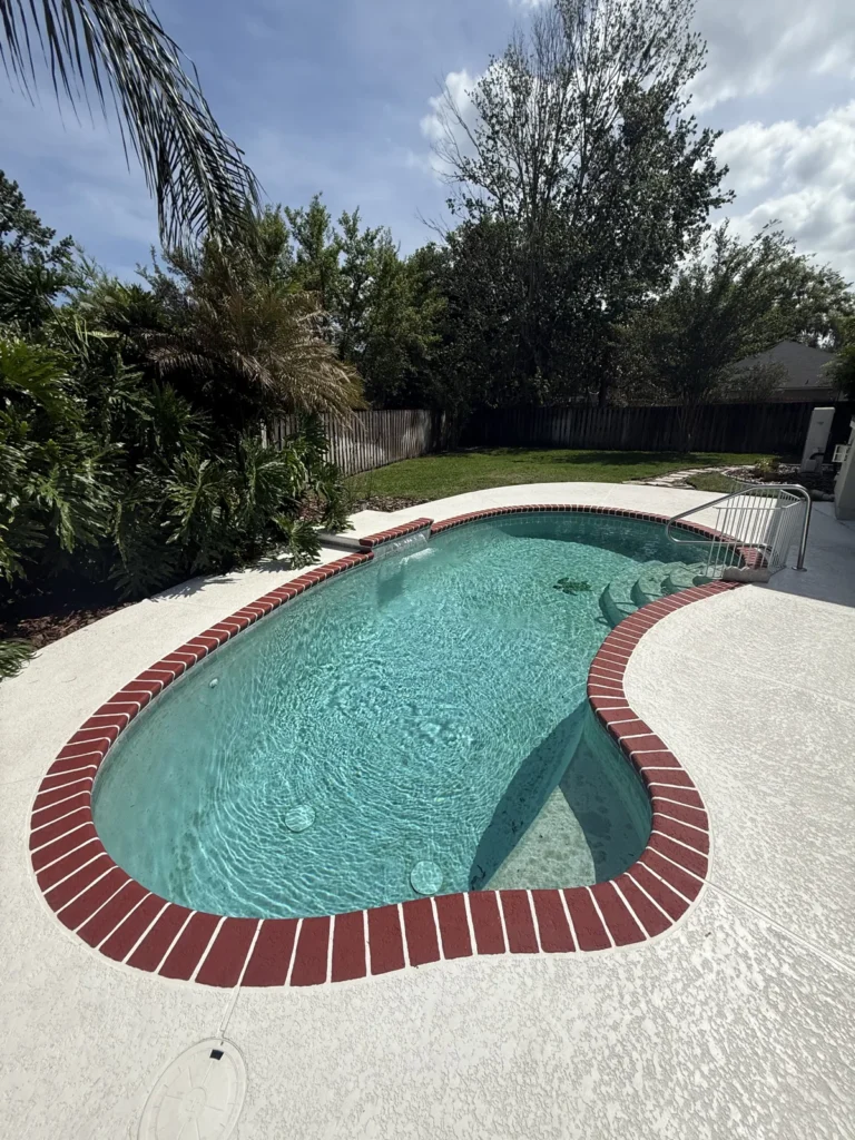 Pool with red brick coping and clear teal water