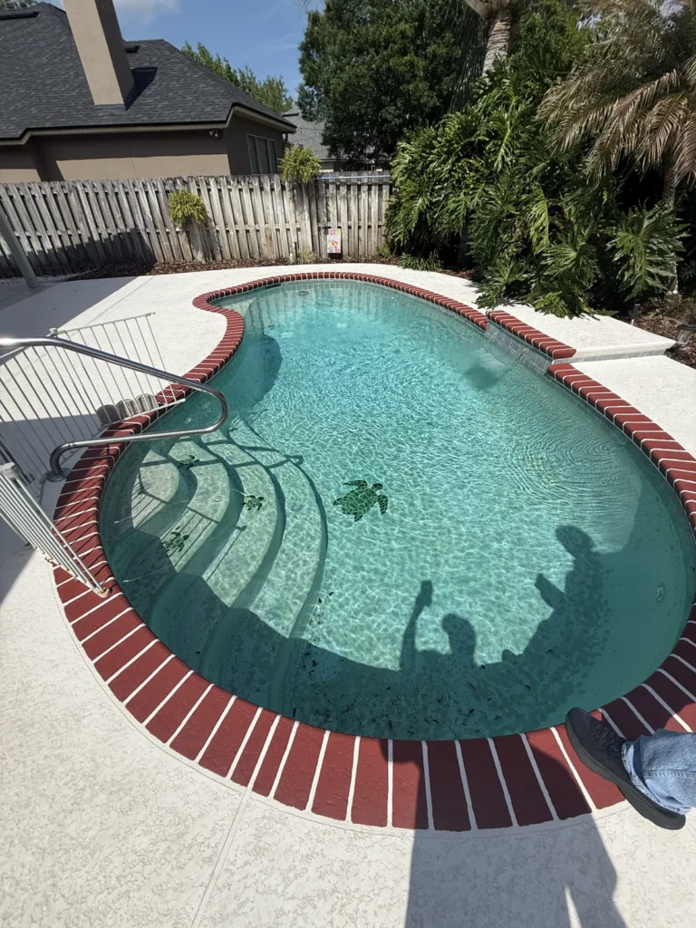 Overhead view of a pool with brick coping and a concrete deck