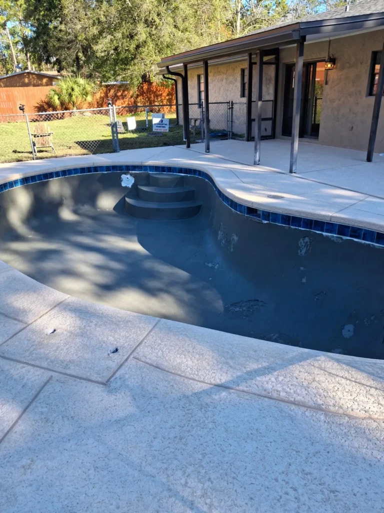 Concrete pool shell after fresh dark plaster was applied, before filling
