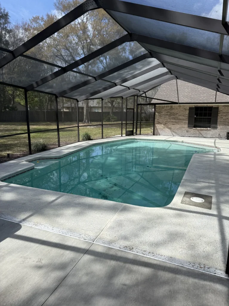 Pool and spa inside a screen enclosure on a paver deck
