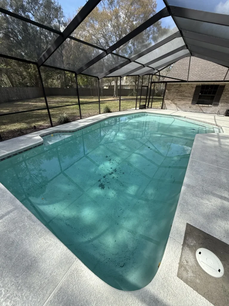 Screened pool enclosure with a pool and attached spa in Northeast Florida